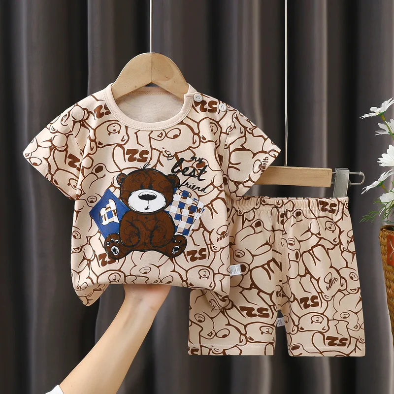 Conjunto de roupa infantil de algodão puro com estampa de desenho animado, composto por camiseta e shorts em cores contrastantes. Ideal para uso casual e moderno.
